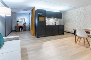 a kitchen with black cabinets and a dining room at appartement - sauna - natuur - Utrecht in Soest