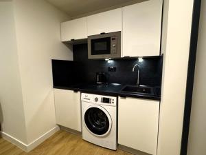 a kitchen with a washing machine and a microwave at Factory Suites in Prague