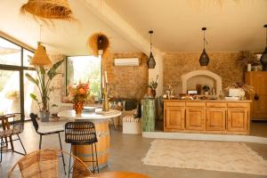 a kitchen with wooden cabinets and a table and chairs at Les Terrasses de Bélarga - Maison d'hôtes - Piscine et Jacuzzi in Bélarga