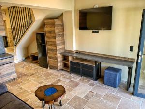 a living room with a table and a tv on the wall at RCR The Stones in Flogita