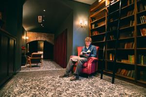 a man sitting in a chair reading a book at CODE - The Court, Edinburgh in Edinburgh +112 photos