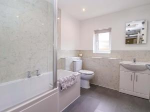 a bathroom with a tub and a toilet and a sink at The Granary in York +13 photos