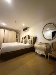 a bedroom with a bed and a mirror and a chair at Catherine Villa in Lagos +24 photos