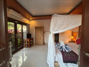 a bedroom with a bed with a canopy at pondok ubud nia cahya in Tegalalang
