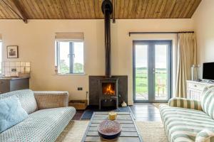 a living room with couches and a fireplace at 1 Bed in Wickhambrook oc-tosh in Wickhambrook
