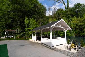 a white gazebo with a black roof next to two bikes at Casa Maya in Băile Govora