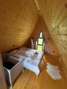 a bedroom with a bed in a wooden attic at Brvnare na Oku Zlatibor in Ocka Gora