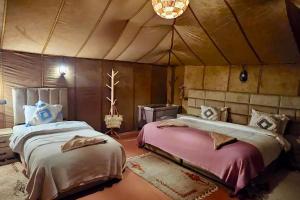a bedroom with two beds in a tent at Unique Luxury Camp in Merzouga