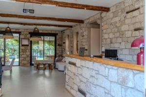 a kitchen and living room with a stone wall at Moranka by ALS ALAÇATI in Alaçatı