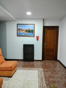 ein Wohnzimmer mit einem orangefarbenen Sofa und einer Tür in der Unterkunft Hotel Salldemar in Santillana del Mar