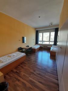 a room with two beds and a table in it at Internationales Gästehaus in Jena +25 photos