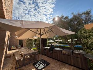 a patio with an umbrella and a table and chairs at Finca Latenéa in Islas Baleares