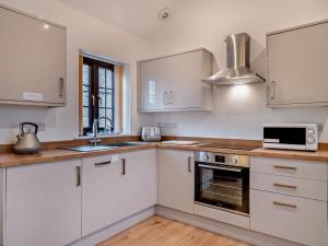 a kitchen with white cabinets and a sink and a microwave at 2 Bed in Bristol oc-72836 in Chew Magna +10 photos