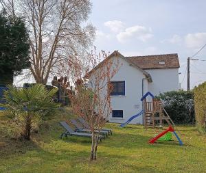 a yard with a playground and a house at Les petits logis de l'Écluse in Noyers-sur-Cher