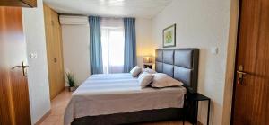 a bedroom with a bed with pillows and a window at Sunny house KIMI in Omiš