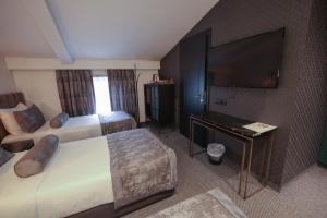 a hotel room with two beds and a flat screen tv at Hotel Rubis in Ferizaj