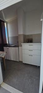 a kitchen with white cabinets and a counter top at Sunny house KIMI in Omiš