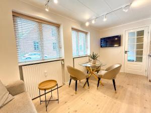 a living room with a table and chairs at Det Gamle Vaskeri - Historical Apartment in Horsens in Horsens