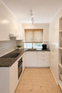 a kitchen with white cabinets and a window at Det Gamle Vaskeri - Historical Apartment in Horsens in Horsens +7 photos