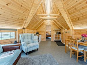 a living room with a couch and a chair and a table at 1 Bed in Lanark oc-91252 in Libberton