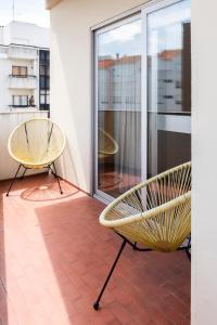 two yellow chairs sitting on a balcony with a window at RH Charming Apartment - D Nuno in Barcelos