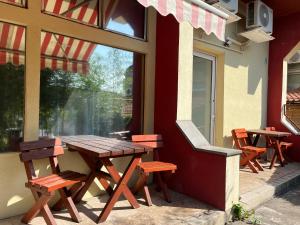 a wooden table and chairs on the side of a building at Centr00m Apartman in Dunaföldvár