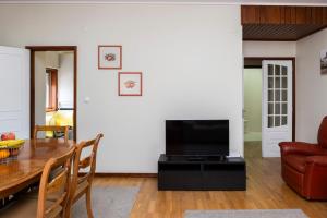 a living room with a table and a television at RH Charming Apartment - D Nuno in Barcelos