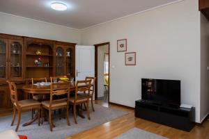 a dining room with a table and chairs and a television at RH Charming Apartment - D Nuno in Barcelos