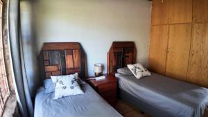 two beds in a small room with at Emmanuel Self-Catering Cottage in Thabazimbi