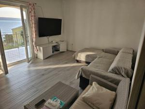 a living room with a couch and a flat screen tv at Jelena Holiday House in Karlobag