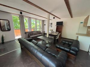 a living room with a leather couch and a table at Beach House Cabacum in Golden Sands