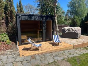 two chairs on a deck in front of a shed at POGO dom nad Narwią - 4 sypialnie, duża sauna, balia, pomost, plac zabaw in Pogorzelec
