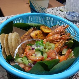 a blue basket of food with shrimp and chips at Backpack Cabin A 49149 in Oranjestad