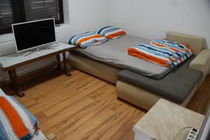 ein Zimmer mit einem Bett, einem Schreibtisch und einem Computer in der Unterkunft Kod Hamde in Jajce