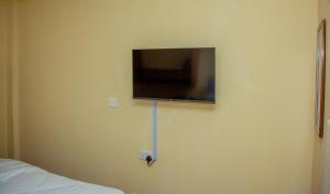 a flat screen tv on the wall of a bedroom at Mustard studio with free WI-FI in Nanyuki