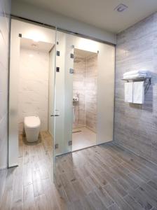 a bathroom with a toilet and a glass shower stall at Geosung Hotel in Eumseong