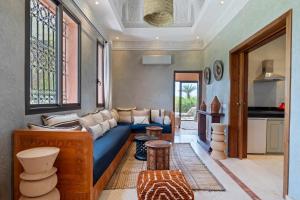 a living room with a blue couch and a table at Bab Akoul Atlas - Boutique Hotel & Spa in Aït Namous