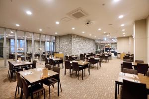 a restaurant with tables and chairs and a brick wall at Geosung Hotel in Eumseong