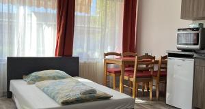 a bedroom with a bed and a table and chairs at Centr00m Apartman in Dunaföldvár