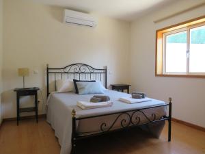 a bedroom with a bed with two towels on it at Casal do Porto - Um refugio de férias in Vila Verde +39 photos