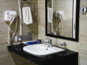 a bathroom with a sink and a mirror and a phone at Donyi Polo International in Itānagar +43 photos