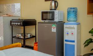 a kitchen with a refrigerator and a microwave at Mustard studio with free WI-FI in Nanyuki