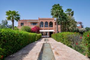 a house with a pond in front of a garden at Bab Akoul Atlas - Boutique Hotel & Spa in Aït Namous