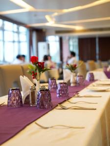 a long table with purple napkins and red flowers on it at Donyi Polo International in Itānagar