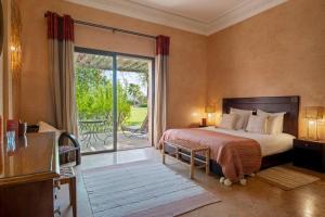 a bedroom with a bed and a sliding glass door at Bab Akoul Atlas - Boutique Hotel & Spa in Aït Namous +74 photos