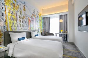 una camera con due letti e un murale di YELLO Hotel Harmoni a Giacarta