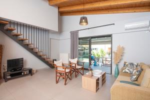 a living room with a couch and a tv and a staircase at Lefkada Town Condo in Lefkada