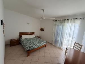 a bedroom with a bed and a table and a window at Top Leme Bedje in Santa Maria