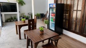 a dining room with two tables and a refrigerator at Weligama Bay House in Weligama