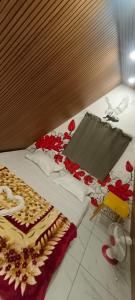 a bed with white sheets and red flowers on it at Varattumedu Hill in Vagamon